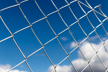 Fondo de pantalla de carcel alambrada reja de alambre sobre un fondo azul de cielo con nubes