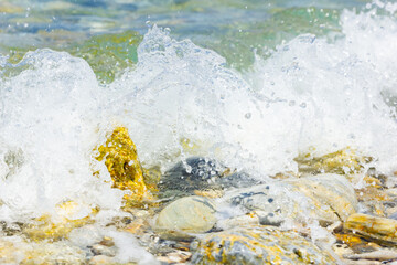 Sea wave and pebble. Summer vacation concept. Sea wave with foam incident on the coastal shingle. Travel concept