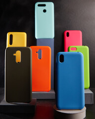 colorful cases for modern smartphones stand on stands on the table side view blurred background