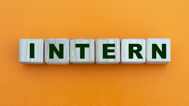INTERN - word on wooden cubes on a beautiful yellow background