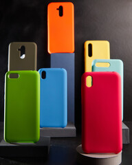colorful cases for modern smartphones stand on stands on the table side view blurred background