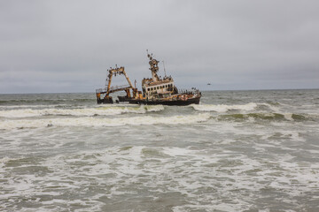 Fototapeta na wymiar Russian fishery shipwreck on the Atlantic coast in Skeleton Coast of Namibia, Southern Africa...