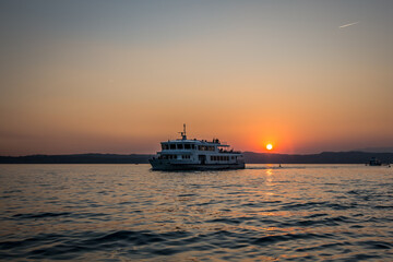 Fototapeta premium Passenger ship on the background of the sunset on Lake Garda. Lombardy, Italy