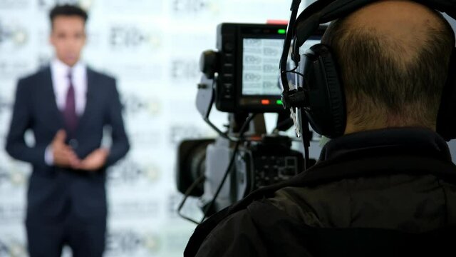 Television Operator On TV Broadcasting Production Channel. Camera Operator On News Room Shoot Media Movie. Cameraman Working In TV Studio Video Production Filming Interview. Making TV Show Or Film.
