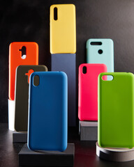 colorful cases for modern smartphones stand on stands on the table side view blurred background
