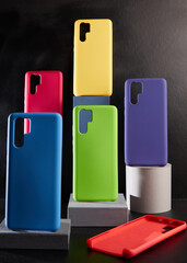 colorful cases for modern smartphones stand on stands on the table side view blurred background