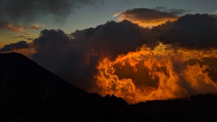 Fototapeta premium atardecer naranja sobre el volcan de izalco, nubes de fuego, so ardiente