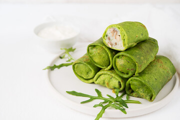Homemade green vegetarian pancakes with filling ( potatoes and mushrooms), vegetable food, spinach pancakes on a white background