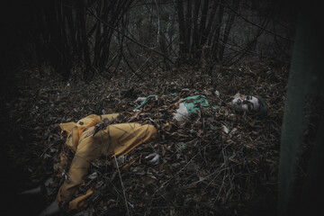 dead girl in autumn foliage wearing green and yellow robes
