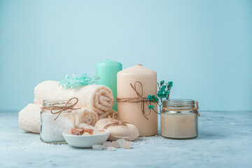 Spa set with candles on a light blue background. Side view with copy space. The concept of body care.