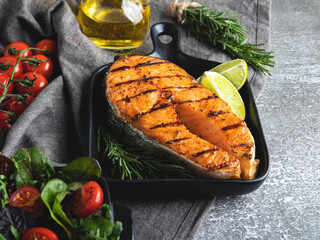 grilled steak fish salmon, trout in a grill pan, spices, fresh salad, tomato,