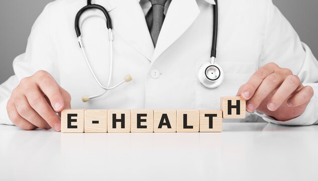 Doctor holds wooden cubes in his hands with text E-HEALTH