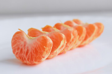 macro photo mandarin slices in a white plate close up several pieces of lie on the table background out of focus