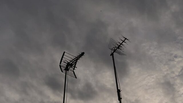 A time-lapse of TV antennas under a dark cloudy sky pon shot in HD