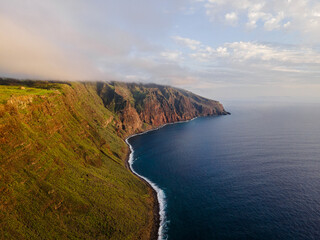 Fototapeta na wymiar Stunning cliff coast of the island of Madeira at sunset - Steep coast with huge cliffs