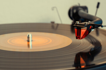 Close-up of turntable pick-up and needle hovering over vinyl record