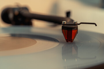 Close-up of turntable pick-up and needle playing a bright vinyl record