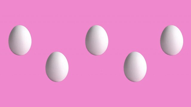 funny animation with chicken raw eggs on rose and pink background, close-up. side view of farm products, easter concept with copy space