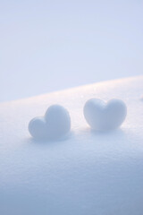 Two snowy hearts. Romantic winter background.