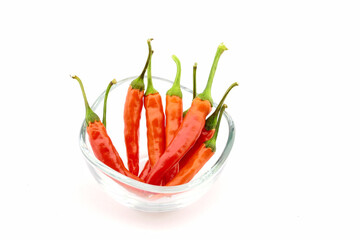 composition of hot peppers in a transparent glass bowl on a white background