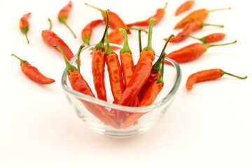 composition of hot peppers in a transparent glass bowl on a white background