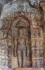 Badami, Karnataka, India - November 7, 2013: Jain Cave temple above Agasthya Lake. Closeup of one brown stone and molded  Jain Digambara Sadhu naked man sculptures.