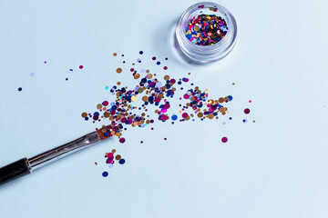 Set of cosmetic tools for manicure and pedicure on a blue background. Makeup bone, sequins, top view.