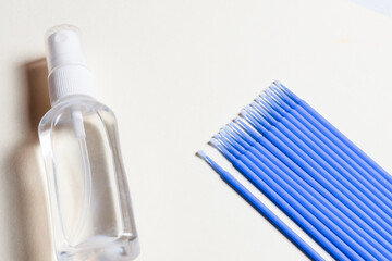 Set of cosmetic tools for manicure and pedicure on a yellow background. Microbrush, disinfector, top view.