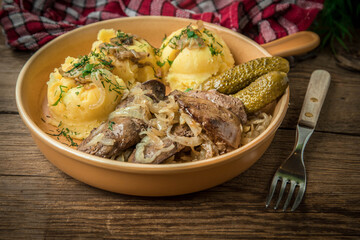 Fried chicken liver with onion served with mashed potatoes and pickled cucumber.