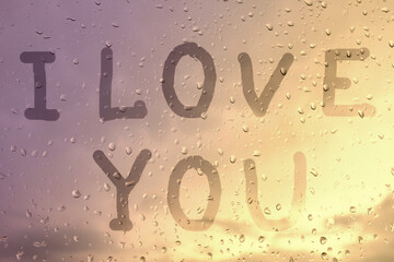 I love you, the inscription on the glass with raindrops in the sunset light.
