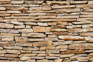 Rough masonry of the wall with orange old sandstone.