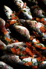 close-up photo of raw sardines with bell pepper and oil