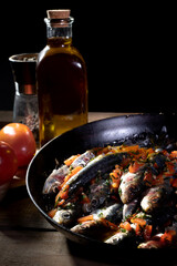 grilled fish with vegetables. frying pan with meat.
still life of frying pan with fish, tomatoes and olive oil