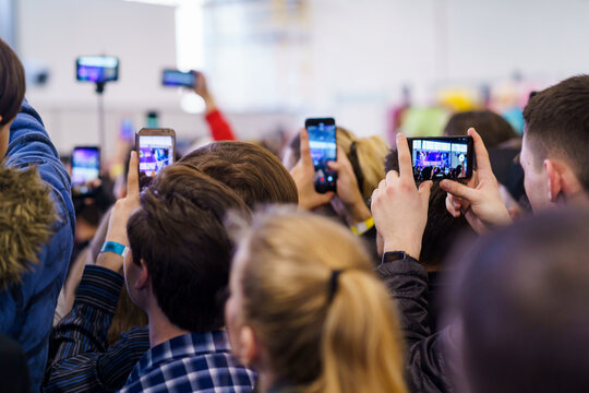Crowd recording video with their smartphones at a conference event