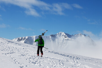 Fototapeta na wymiar Skier with skis go up to top of mountain
