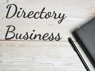 Phrase Directory Business written on wooden background with pen and book. Business concept.