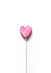 Heart shape pink lollipop on the white background. Valentine's day greeting card	