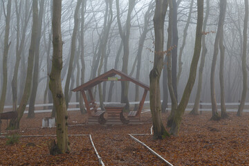 Tourist resting place in autumn misty forest