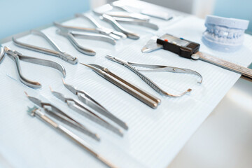 Dental tools and artificial jaw model for the orthodontic treatment lying on the table at the dental office, close-up. High quality photo