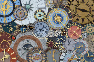 multicolored collection of ancient church tower clocks on a pile in different sizes and forms with roman numbers