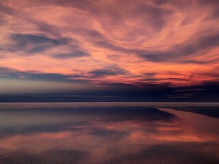 Fototapeta na wymiar Purple sunset in surreal heaven over shiny sea, fantasy landscape, pink clouds in sky, romantic twilight, beautiful dusk, stunning nature at night.