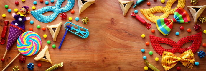 Purim celebration concept (jewish carnival holiday) over wooden background. Top view, flat lay