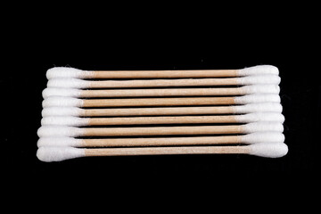 Eco-friendly materials. Wooden, cotton swabs on a black background. Close-up.
