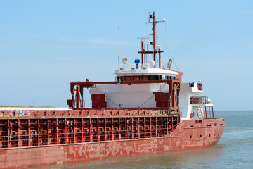 Stern view of an red hulled general cargo ship 