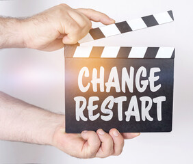 On a white background, a man holds a clapperboard in his hands on which it is written - CHANGE...