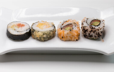 Sushi with salmon, avocado and red tuna on white plate