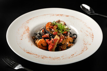 Black pasta with seafood in a deep plate