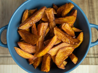 homemade serving of fries. French fries in a bowl on a wooden table.