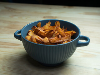 homemade serving of fries. French fries in a bowl on a wooden table.