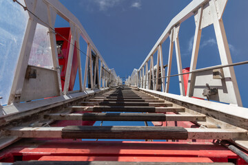 Obraz premium Fire truck ladder leading to the sky.